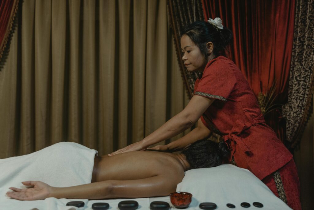Spa treatment with a masseuse providing a relaxing back massage in a serene setting.